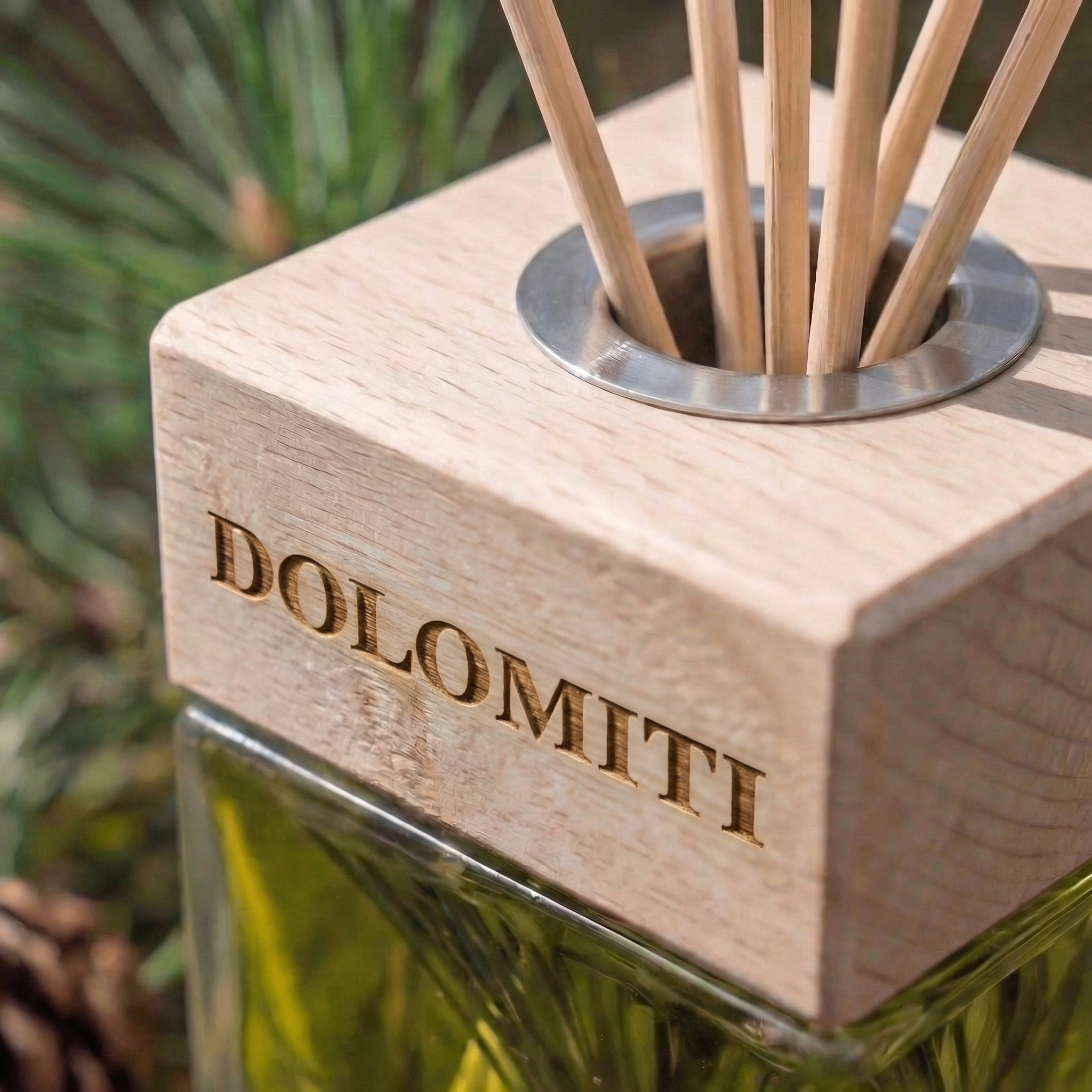 Dettaglio del tappo in legno inciso Dolomiti con i bastoncini del diffusore
