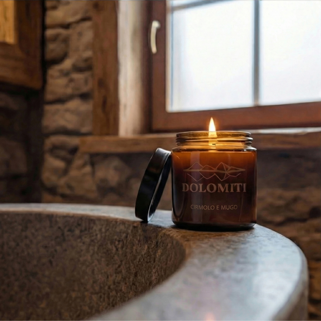 Candela al pino cirmolo su lavabo in pietra in un bagno rustico