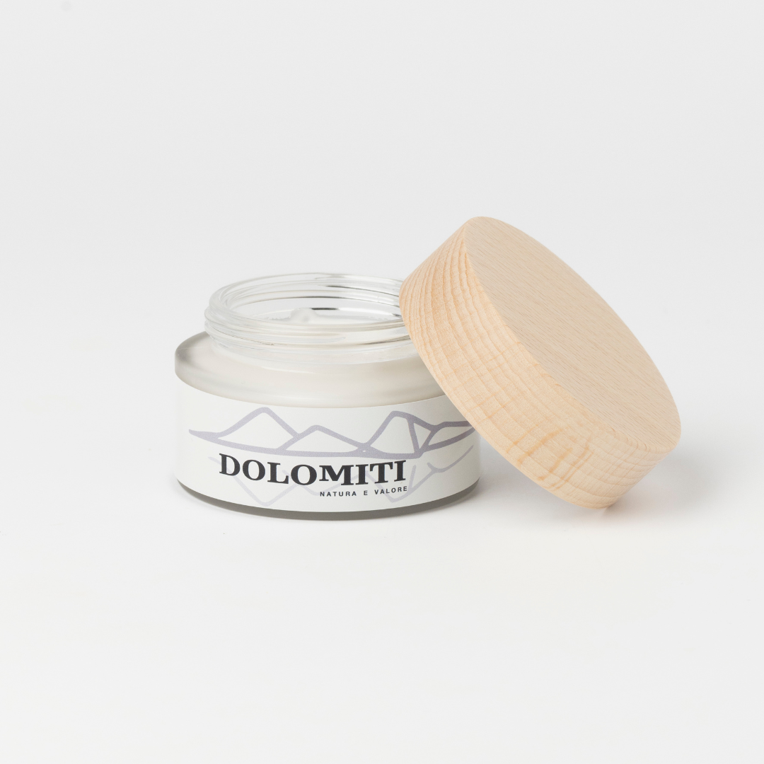 Vasetto aperto della crema viso Dolomiti con la texture bianca visibile
